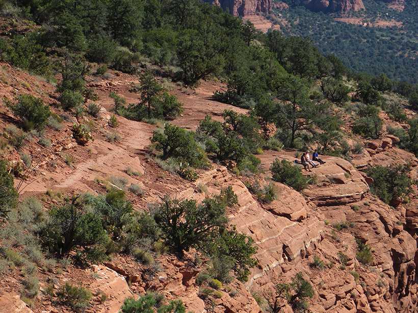 Distant view of Coconino Loop Trail with Hikers enjoying the view at the edge of the cliff.