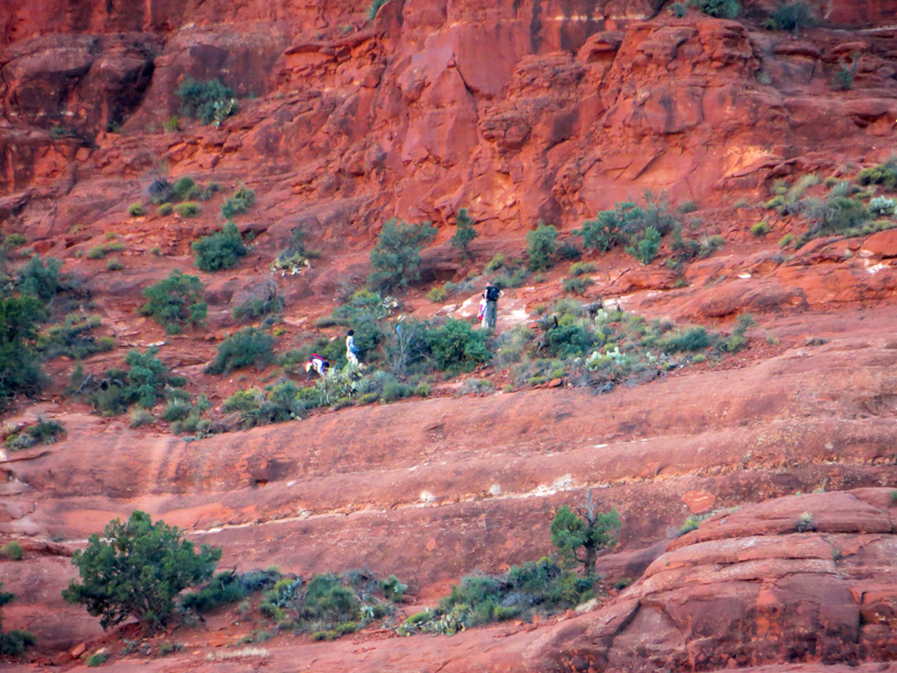Hikers along the sloping dirt path that ascends the eastern face of Beil Rock.